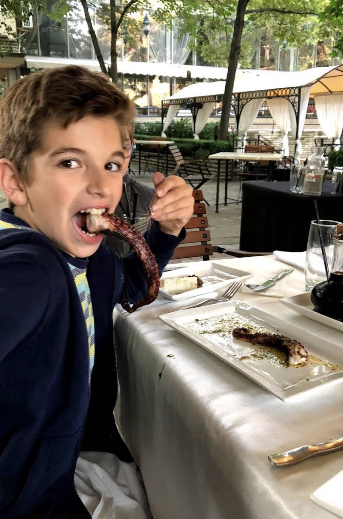 A young Vladislav trying octopus at a restaurant